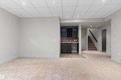 Recessed lighting, drop ceiling, built-in wet bar with cabinetry, tile backsplash, and carpeted flooring - 