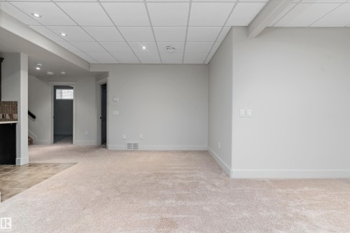 Recessed lighting, light-toned walls, neutral carpeting, drop panel ceiling, and an open doorway - 17535 110 Street Nw, Edmonton, AB 