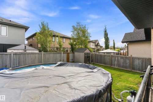 Backyard featuring an above-ground pool, a storage shed, a wooden fence, and a manicured lawn - 17535 110 Street Nw, Edmonton, AB 
