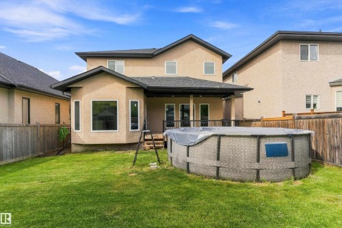Expansive backyard with a manicured lawn, an above-ground pool, and a covered patio area - 17535 110 Street Nw, Edmonton, AB 