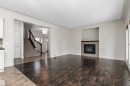 Rich wood-finish flooring, recessed lighting, and a fireplace with a decorative tile surround and dark mantel - 17535 110 Street Nw, Edmonton, AB 