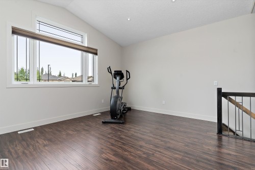 Vaulted ceiling, wood-finish flooring, large window with transom, and metal and wood railing - 17535 110 Street Nw, Edmonton, AB 