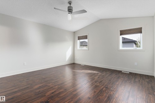 Vaulted ceiling, wood-finish flooring, two windows, ceiling fan with light, and neutral wall tones - 17535 110 Street Nw, Edmonton, AB 