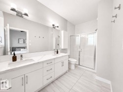 Dual vanity with integrated sinks, quartz-finish countertop, and full-width mirror - 