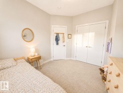 Plush carpeting, a built-in closet with double doors, and a wood-finish dresser with unique hardware - 