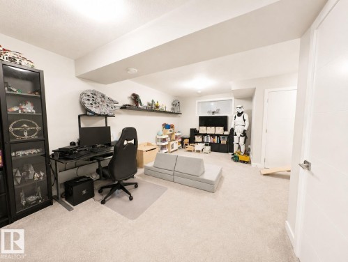 Recessed lighting illuminates a spacious room featuring light-toned carpeting and white walls - 10516 76 Street Nw, Edmonton, AB 