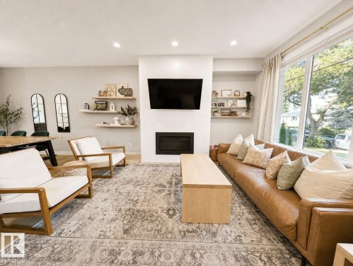 Recessed lighting, wood-finish flooring, built-in fireplace, large picture windows, and light neutral wall tones - 10516 76 Street Nw, Edmonton, AB 