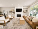 Recessed lighting, wood-finish flooring, built-in fireplace, large picture windows, and light neutral wall tones - 10516 76 Street Nw, Edmonton, AB 