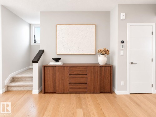 Hardwood flooring, carpeted staircase, wood-finish cabinetry, modern interior door, light-colored walls - 10516 76 Street Nw, Edmonton, AB 