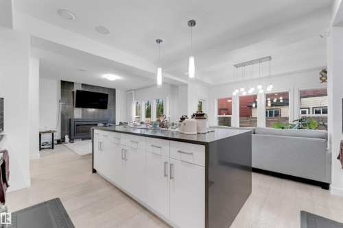 Central island featuring white cabinetry and a dark countertop - 718 Charlesworth Way Sw, Edmonton, AB 