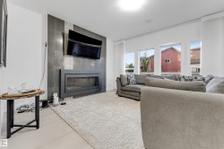 Integrated linear fireplace with a dark-toned tile surround extending to the ceiling - 