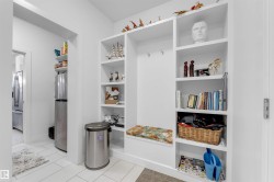 Built-in storage unit with shelving, coat hooks, and integrated seating - 