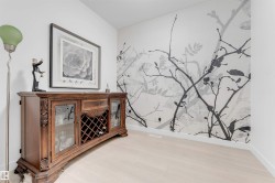 Light wood-finish flooring and an accent wall with a branch motif - 