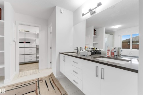 Double vanity with integrated sinks, white cabinetry, and brushed nickel hardware - 718 Charlesworth Way Sw, Edmonton, AB 