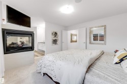 Wall-mounted fireplace with an integrated media shelf, soft carpet flooring, and a ceiling-mounted light fixture - 