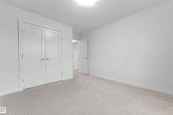 Light-toned wall-to-wall carpeting, white interior doors with contemporary hardware, and overhead flush-mount lighting - 