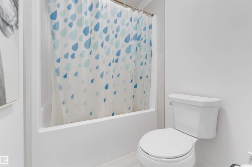 White tile flooring and a built-in bathtub with shower - 718 Charlesworth Way Sw, Edmonton, AB 