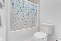 White tile flooring and a built-in bathtub with shower - 