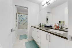 Dual vanity with integrated sinks, modern flat-panel cabinetry, and a full-width mirror - 