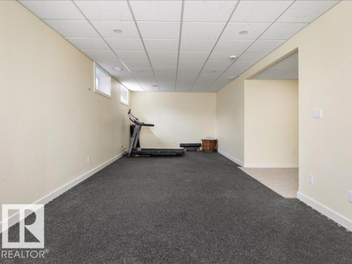 Spacious room featuring neutral painted walls, recessed lighting, and a drop ceiling - 496 Ravine Court, Devon, AB 