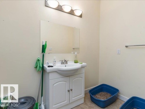 Vanity with integrated basin, wall-mounted mirror, and overhead light fixture - 496 Ravine Court, Devon, AB 