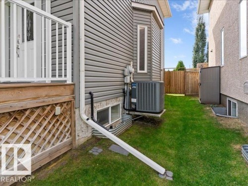 Gray horizontal siding exterior with a white deck railing, wooden lattice deck skirting, and a fenced perimeter - 496 Ravine Court, Devon, AB 