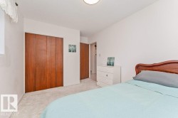 Bedroom featuring light-colored carpeting, white walls, a flush-mount ceiling light, and a window with a sheer curtain - 