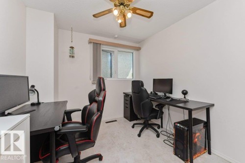 Bright room featuring a window with a valance, light-colored carpeting, a ceiling fan with integrated lighting, and neutral wall tones - 11415 56 Avenue Nw, Edmonton, AB 