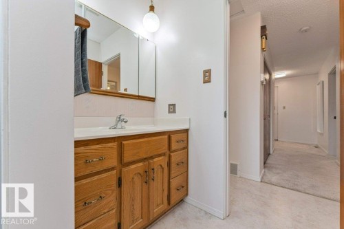 Bathroom vanity with a white countertop, undermount sink, and chrome faucet - 11415 56 Avenue Nw, Edmonton, AB 