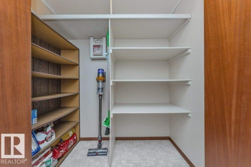 Huge pantry with motion sensor light. Built-in shelving with adjustable white shelves and wood-finish shelving. - 11415 56 Avenue Nw, Edmonton, AB 