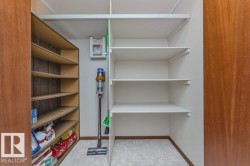 Huge pantry with motion sensor light. Built-in shelving with adjustable white shelves and wood-finish shelving. - 