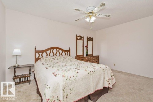 Spacious room featuring neutral wall paint, light-colored carpet, and a ceiling fan with integrated lighting - 11415 56 Avenue Nw, Edmonton, AB 