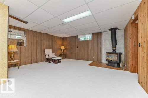 Lower level room featuring wood paneling and a drop ceiling - 11415 56 Avenue Nw, Edmonton, AB 