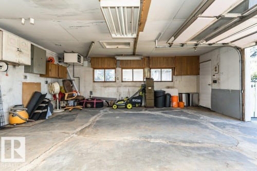 Concrete floor garage with multiple windows and overhead fluorescent lighting - 11415 56 Avenue Nw, Edmonton, AB 