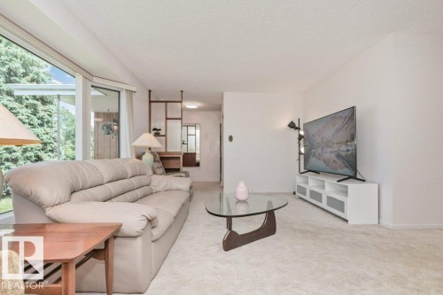 Living area featuring light-toned carpet flooring and white painted walls - 11415 56 Avenue Nw, Edmonton, AB 