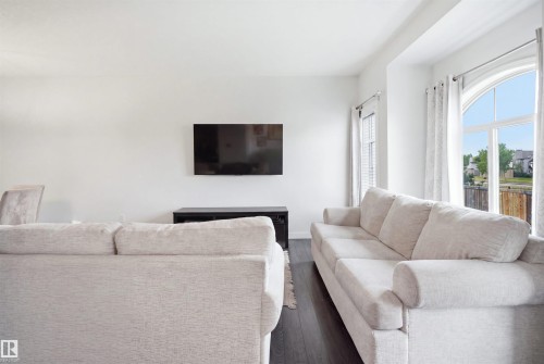 Recessed lighting, wood-finish flooring, and a large arched window with white trim - #22 723 172 Street Sw, Edmonton, AB 