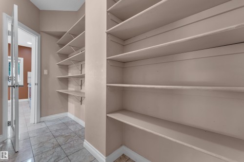 Spacious pantry featuring extensive built-in shelving, tile flooring, and neutral wall tones - 3455 29 Street Nw, Edmonton, AB 