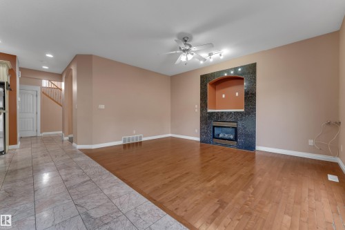 Hardwood flooring, tiled flooring, built-in fireplace with black surround, ceiling fan with track lighting, arched entryway - 3455 29 Street Nw, Edmonton, AB 