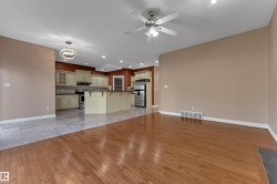 Hardwood flooring, tile flooring, ceiling fan, recessed lighting, and a kitchen island with seating - 