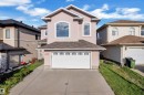 Stucco exterior with an attached garage, a paved driveway, and multiple arch-top windows - 3455 29 Street Nw, Edmonton, AB 