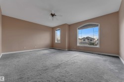 Spacious interior featuring a large arched window, additional sash windows, and a ceiling fan - 