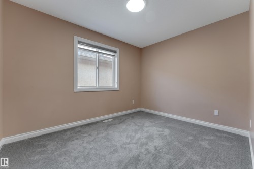 Neutral wall color, grey carpeting, white trim, and a window with white casing - 3455 29 Street Nw, Edmonton, AB 