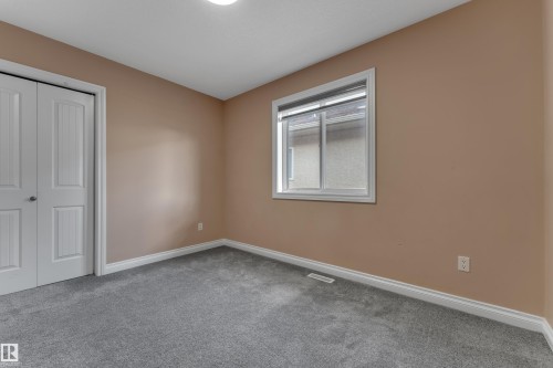 Plush grey carpeting, neutral wall color, white trim, and a double-panel closet - 3455 29 Street Nw, Edmonton, AB 