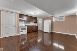 Full kitchen with dark wood-finish cabinetry, white appliances, and a tiled backsplash - 