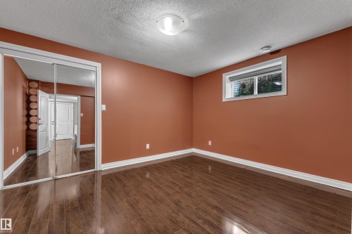 Wood-finish flooring, mirrored sliding closet doors, and recessed window - 3455 29 Street Nw, Edmonton, AB 