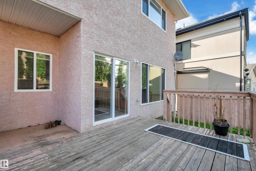 Exterior wood deck featuring a wood railing and multiple windows - 3455 29 Street Nw, Edmonton, AB 