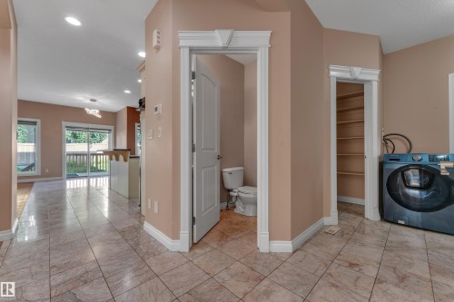 Tile flooring, built-in shelving, white trim, sliding glass doors, and recessed lighting - 3455 29 Street Nw, Edmonton, AB 
