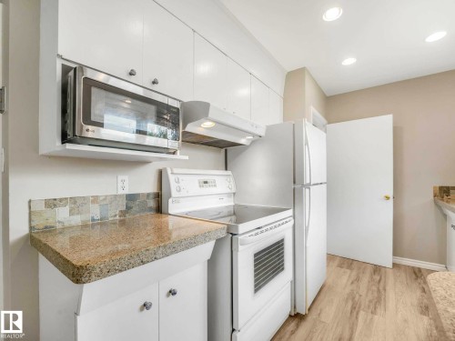 White cabinetry with stainless steel microwave, laminate countertops, tiled backsplash, and recessed lighting - 15916 88B Avenue Nw, Edmonton, AB 