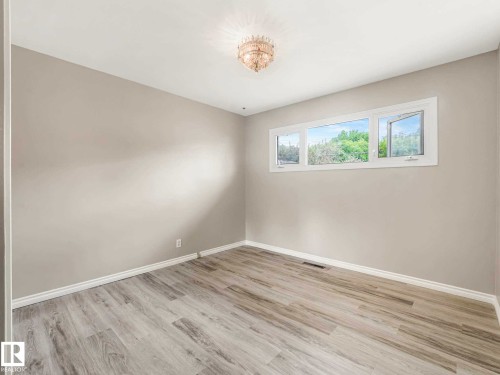 Light-toned wood-finish flooring, crisp white trim, and a multi-pane window - 15916 88B Avenue Nw, Edmonton, AB 