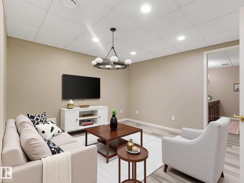 Neutral wall paint, recessed lighting, wood-finish flooring, drop ceiling, and a built-in media console - 15916 88B Avenue Nw, Edmonton, AB 